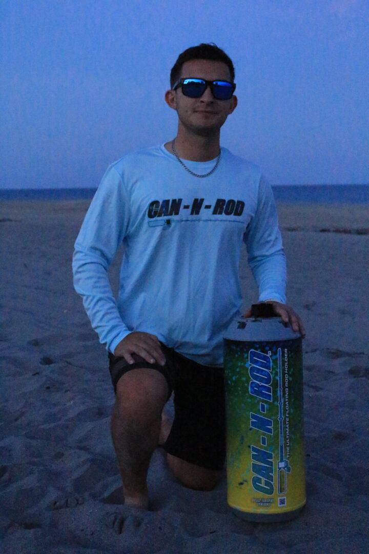 A man holding a can on the beach