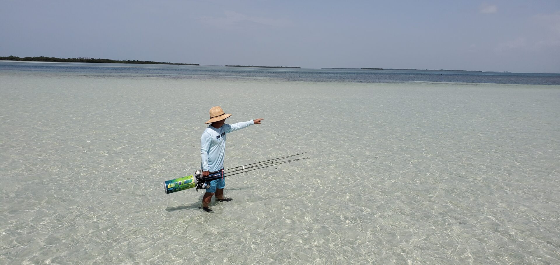 A man standing on the beach holding a kite.