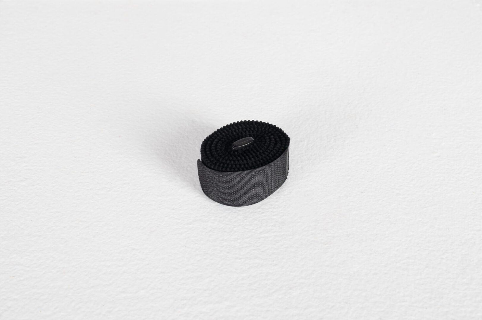 Black Velcro strap on a white background.